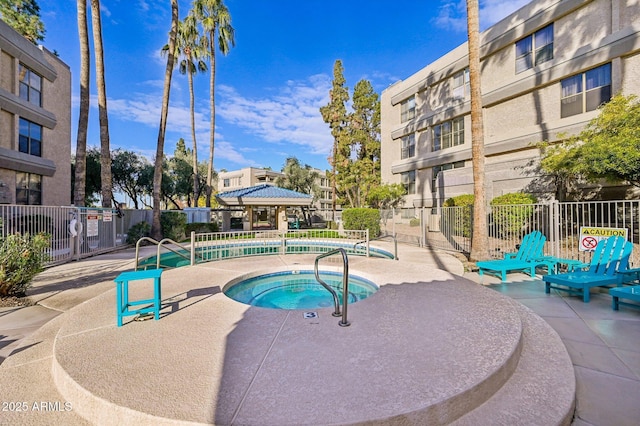 pool featuring fence, a community hot tub, and a patio area