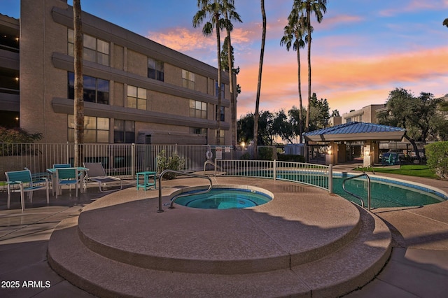 view of swimming pool with a patio, fence, and a community hot tub