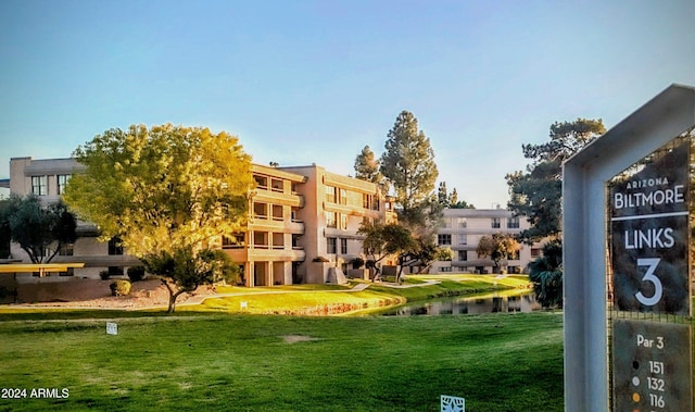 surrounding community with a lawn and a water view
