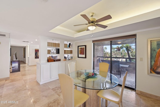 dining area featuring baseboards, a ceiling fan, a raised ceiling, and light tile patterned floors