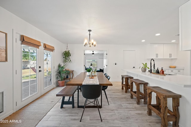 dining space featuring light wood finished floors, baseboards, french doors, a chandelier, and recessed lighting