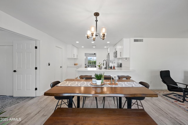 dining area with recessed lighting, visible vents, baseboards, light wood-type flooring, and an inviting chandelier