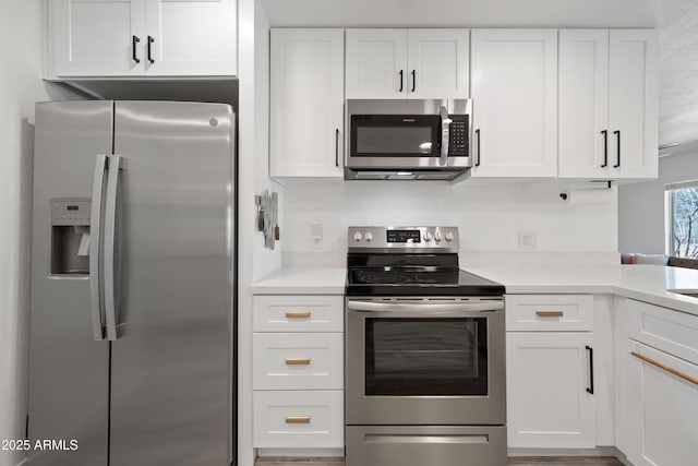 kitchen featuring stainless steel appliances, light countertops, and white cabinets