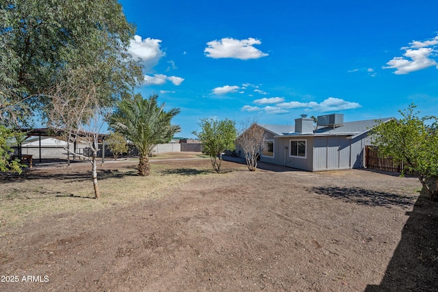 view of yard with central AC and fence