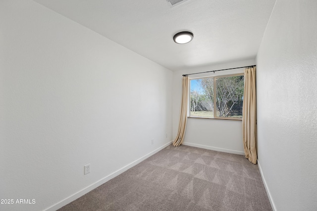 spare room featuring visible vents, baseboards, and carpet flooring