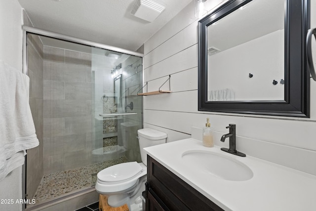 bathroom featuring visible vents, toilet, a textured ceiling, vanity, and a shower stall