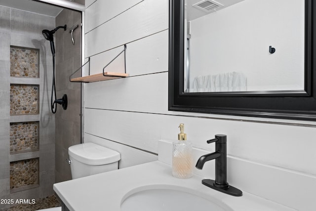 bathroom featuring visible vents, toilet, a shower stall, and vanity