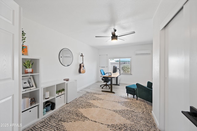 office area with ceiling fan, baseboards, wood finished floors, and a wall mounted air conditioner