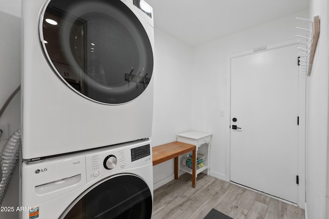 washroom featuring light wood-style floors, laundry area, and stacked washing maching and dryer