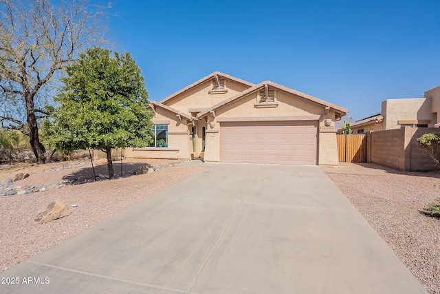 ranch-style home with stucco siding, concrete driveway, an attached garage, fence, and a tiled roof