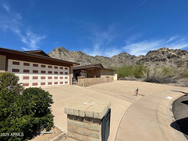 view of front of property featuring concrete driveway, an attached garage, and a mountain view