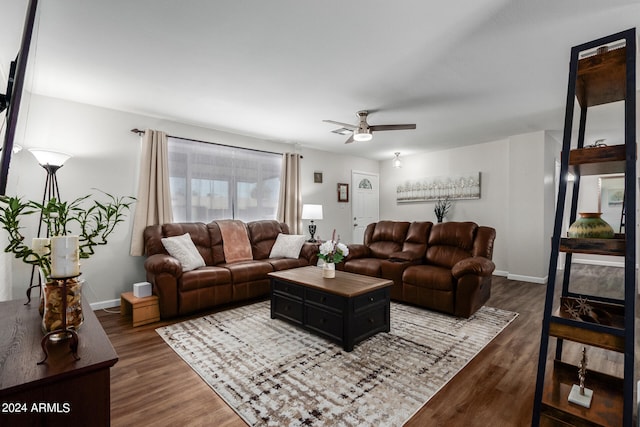 living room featuring ceiling fan and dark hardwood / wood-style floors