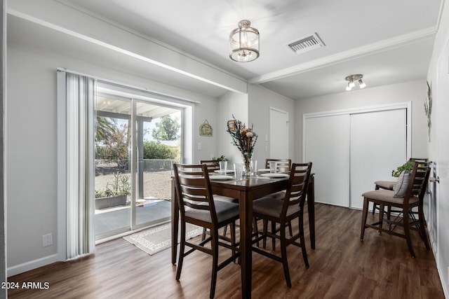 dining area featuring dark wood-type flooring and a chandelier