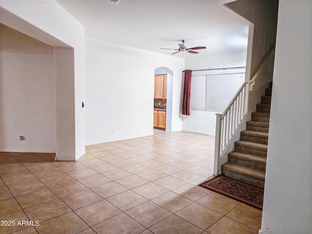 unfurnished living room featuring ceiling fan and light tile patterned floors