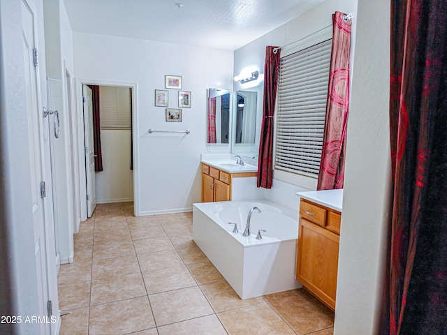 bathroom featuring tile patterned flooring, vanity, and a bath