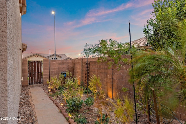 view of yard featuring a fenced backyard and a gate