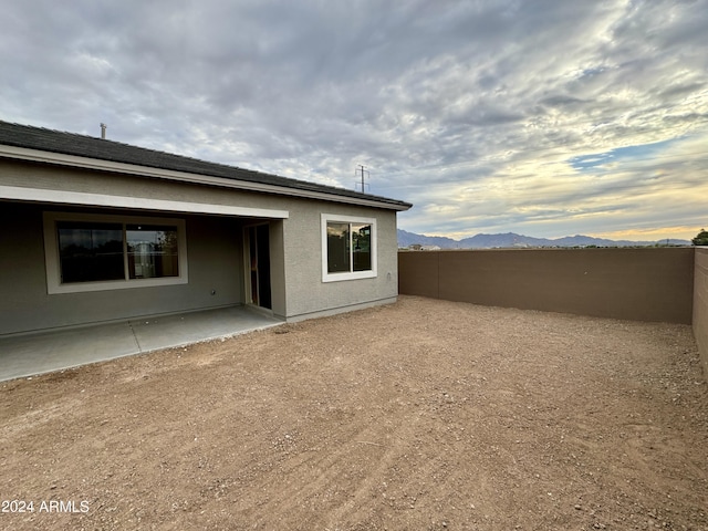 rear view of property with a mountain view and a patio area