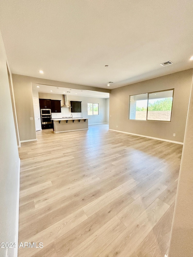 unfurnished living room with light wood-type flooring and a healthy amount of sunlight