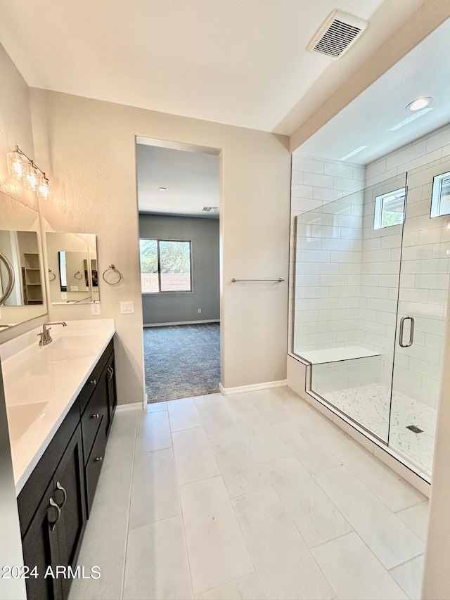 bathroom with vanity, a shower with shower door, and tile patterned floors