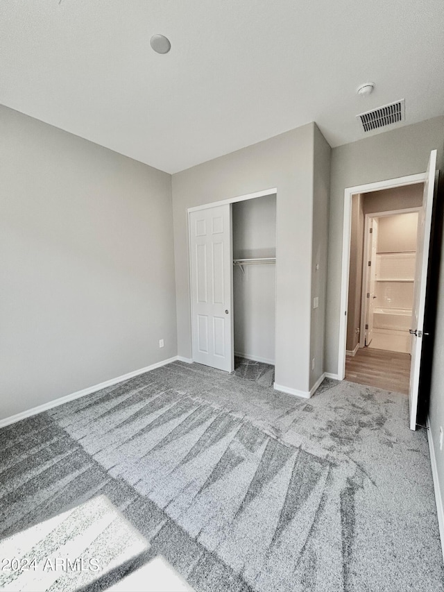 unfurnished bedroom featuring carpet and a closet