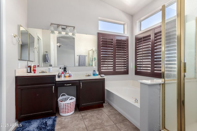 bathroom featuring tile patterned flooring, vanity, a washtub, and ceiling fan