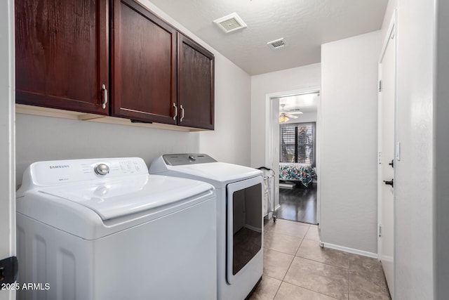 washroom with light tile patterned flooring, cabinets, washer and dryer, a textured ceiling, and ceiling fan