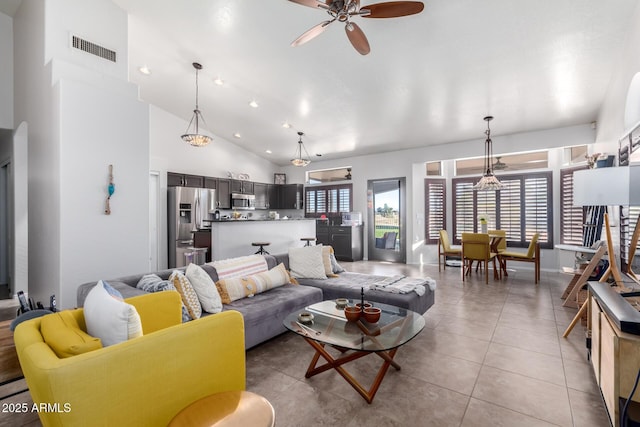 tiled living room featuring high vaulted ceiling and ceiling fan