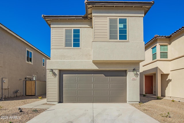 view of front facade with a garage, driveway, and stucco siding