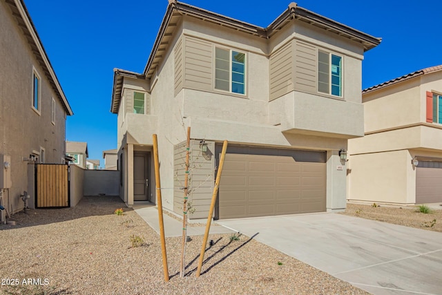 view of front of property featuring a garage, driveway, and a gate