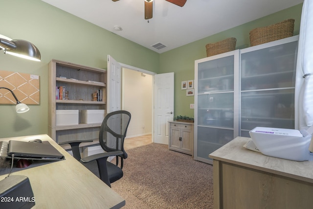 carpeted office space featuring ceiling fan