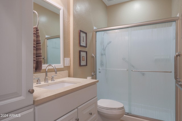 bathroom featuring vanity, toilet, and an enclosed shower