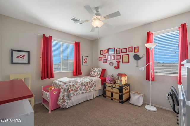 carpeted bedroom with multiple windows and ceiling fan