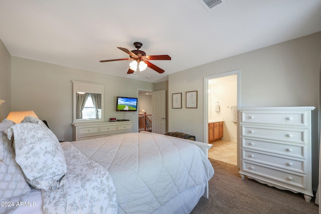 bedroom featuring connected bathroom, ceiling fan, and light colored carpet