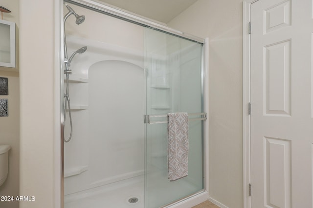 bathroom featuring toilet and an enclosed shower