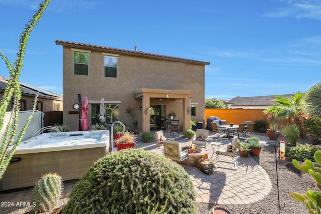 rear view of house with a patio and a hot tub