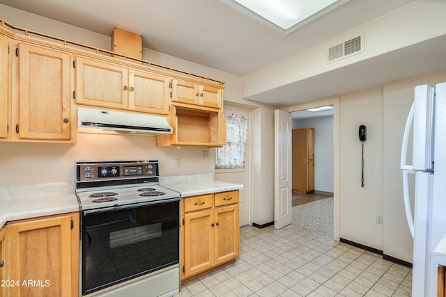 kitchen featuring light brown cabinetry, white refrigerator, and electric range