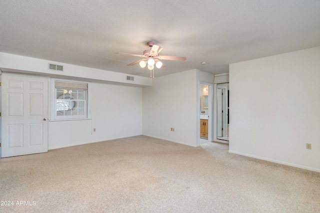 carpeted spare room featuring ceiling fan and a textured ceiling