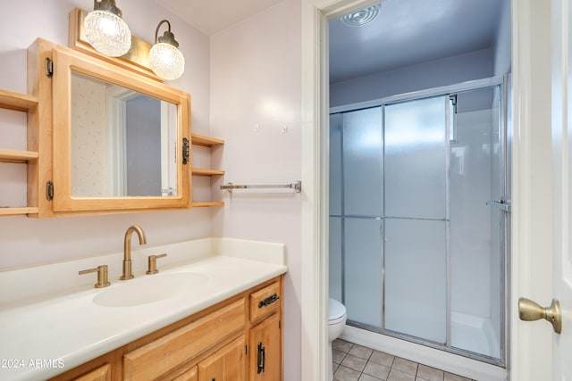 bathroom featuring vanity, toilet, tile patterned floors, and an enclosed shower