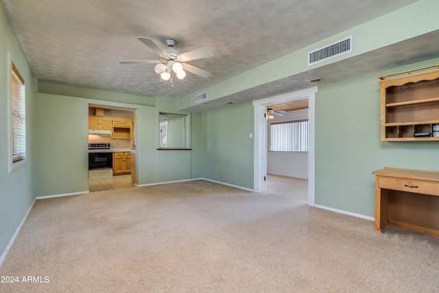 unfurnished living room with a wealth of natural light, ceiling fan, and a textured ceiling