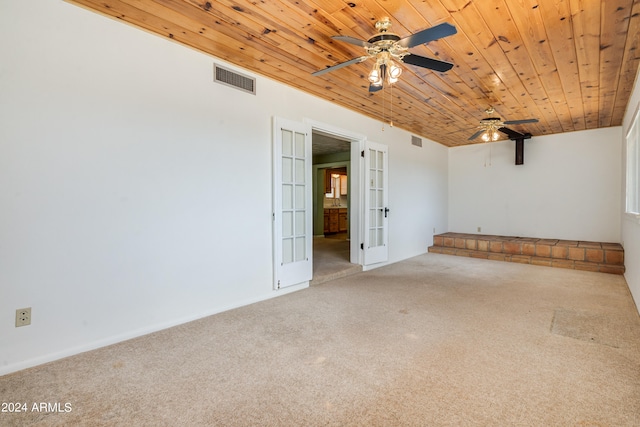 empty room featuring french doors, ceiling fan, wooden ceiling, and carpet flooring