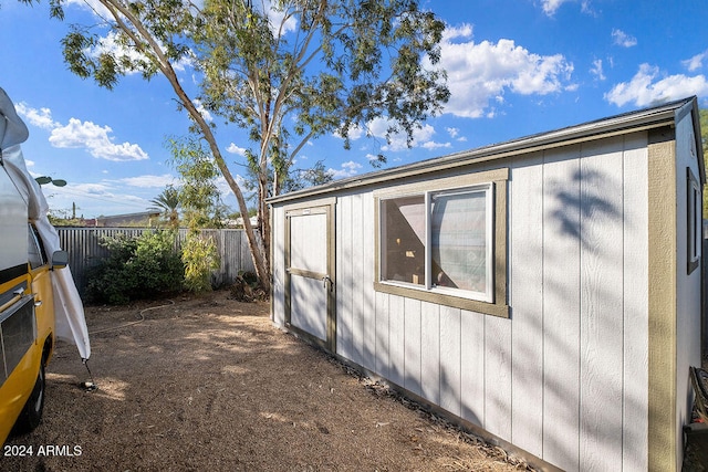 view of side of home featuring a shed