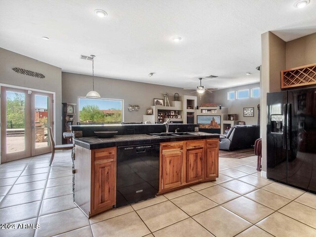 kitchen featuring decorative backsplash, light tile patterned floors, black appliances, and wall chimney range hood