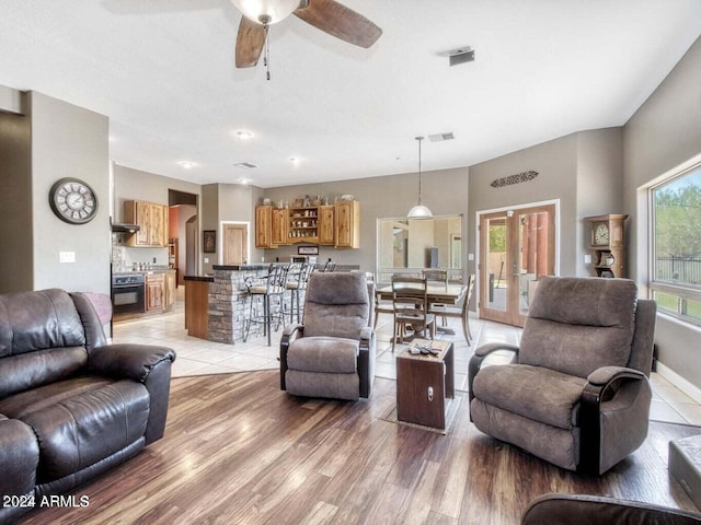 living room featuring ceiling fan, hardwood / wood-style floors, and french doors