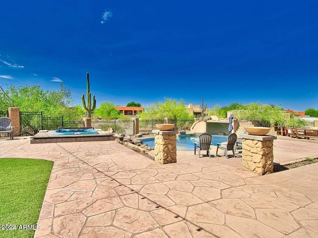 view of patio with pool water feature and a swimming pool with hot tub