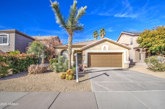 mediterranean / spanish-style house with stucco siding, concrete driveway, an attached garage, and a tiled roof