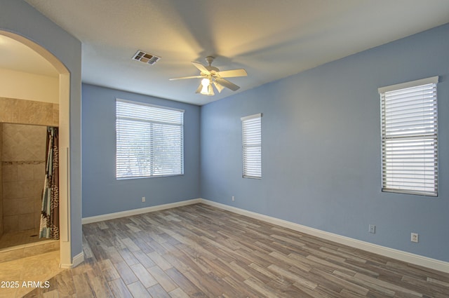 4714 E Paso Trl, Phoenix, AZ 85050 - unfurnished bedroom with visible vents, baseboards, wood finished floors, arched walkways, and a ceiling fan