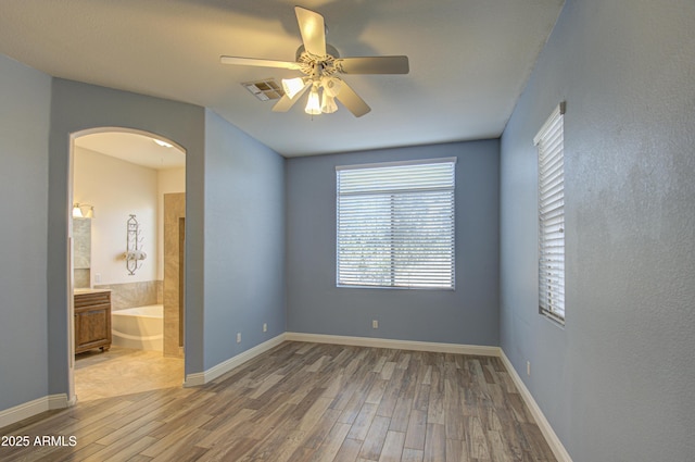 4714 E Paso Trl, Phoenix, AZ 85050 - unfurnished bedroom with visible vents, arched walkways, baseboards, and wood finished floors