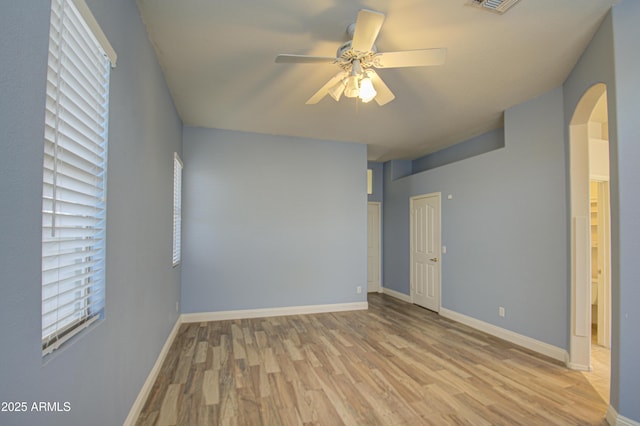 4714 E Paso Trl, Phoenix, AZ 85050 - unfurnished bedroom with wood finished floors, arched walkways, and baseboards