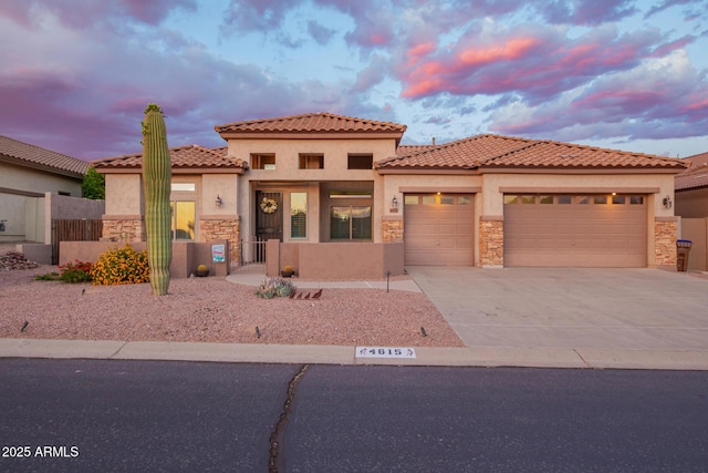 4615 S Primrose Dr, Gold Canyon, AZ 85118 - mediterranean / spanish house featuring concrete driveway, an attached garage, stone siding, and stucco siding