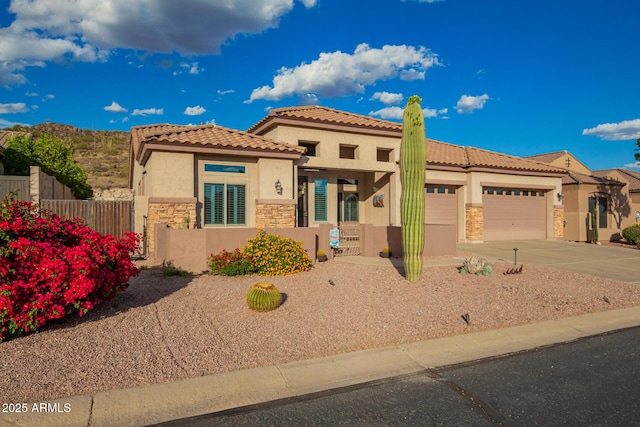 4615 S Primrose Dr, Gold Canyon, AZ 85118 - mediterranean / spanish-style house featuring an attached garage, stone siding, stucco siding, concrete driveway, and fence private yard